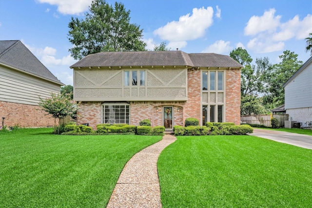 1607 Castlerock Dr, Houston, TX 77090 - tudor home featuring a front yard, brick siding, and a shingled roof