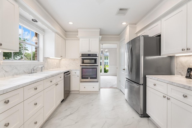 1607 Castlerock Dr, Houston, TX 77090 - kitchen featuring appliances with stainless steel finishes, white cabinetry, light countertops, tasteful backsplash, and light marble finish floors