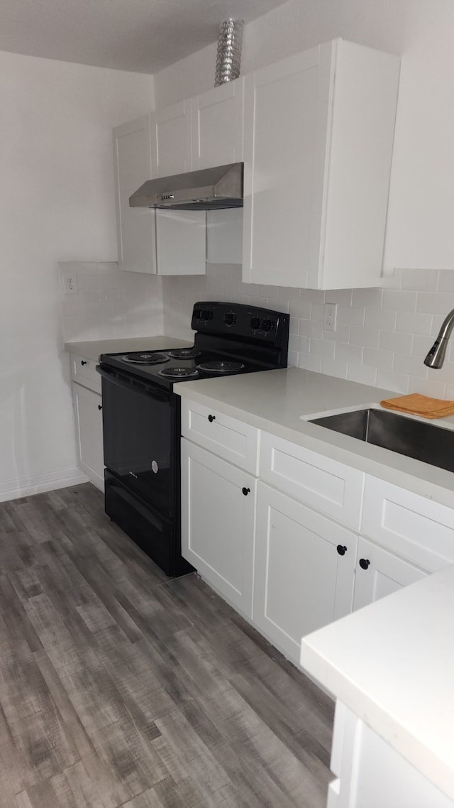 3655 Seabrook St, Houston, TX 77021 - kitchen featuring electric range, wall chimney range hood, white cabinetry, and decorative backsplash