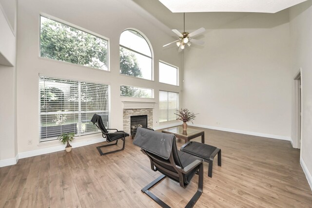3622 Stratford Town Ln, Sugar Land, TX 77498 - living room featuring a high ceiling, a stone fireplace, wood finished floors, and ceiling fan