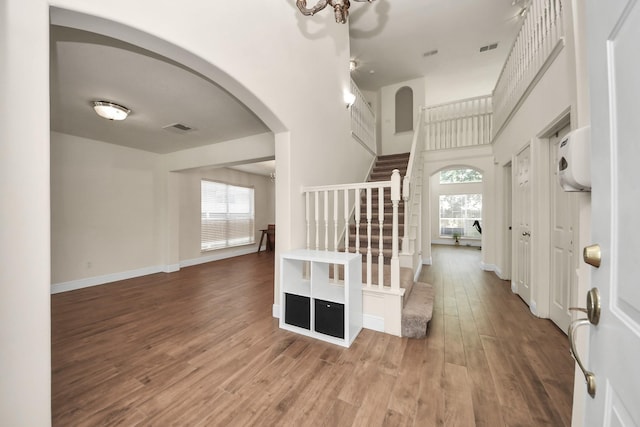3622 Stratford Town Ln, Sugar Land, TX 77498 - entrance foyer with stairway, arched walkways, wood finished floors, and a high ceiling
