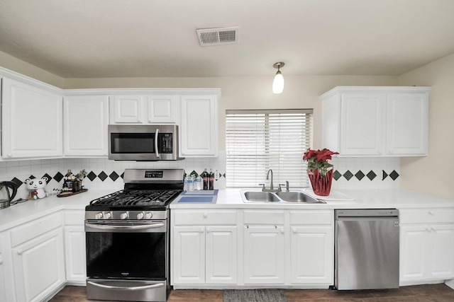3622 Stratford Town Ln, Sugar Land, TX 77498 - kitchen featuring appliances with stainless steel finishes, light countertops, decorative backsplash, white cabinetry, and dark wood finished floors