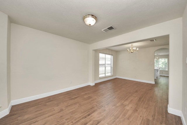 3622 Stratford Town Ln, Sugar Land, TX 77498 - empty room featuring a chandelier, wood finished floors, and arched walkways
