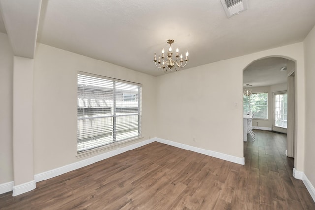 3622 Stratford Town Ln, Sugar Land, TX 77498 - empty room with arched walkways, a chandelier, and dark wood-type flooring