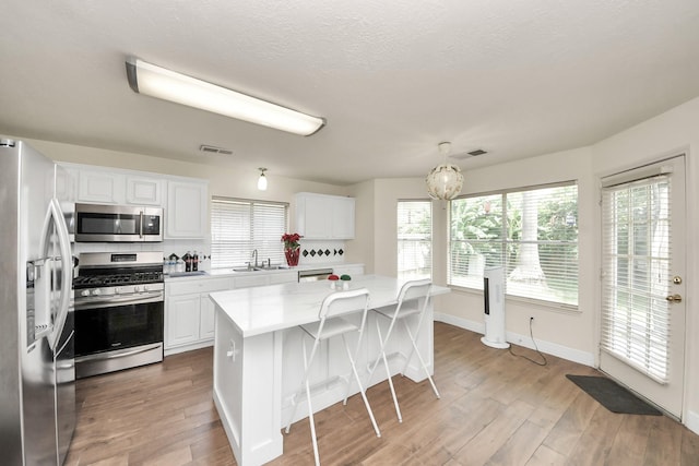 3622 Stratford Town Ln, Sugar Land, TX 77498 - kitchen featuring appliances with stainless steel finishes, white cabinetry, and wood finished floors