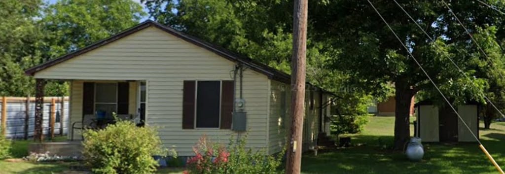1203 Mangrum St, Brenham, TX 77833 - view of side of home featuring a lawn