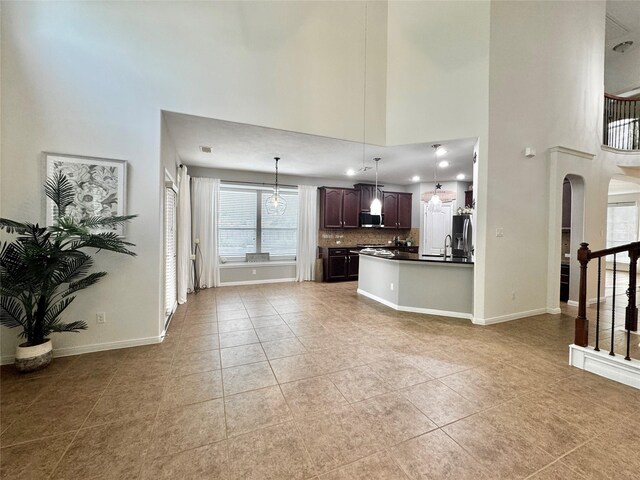 16506 Orchid Mist Dr, Cypress, TX 77433 - unfurnished living room with a high ceiling, light tile patterned flooring, and arched walkways