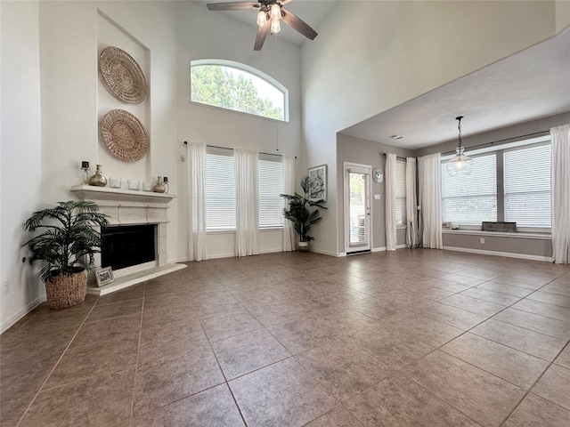 16506 Orchid Mist Dr, Cypress, TX 77433 - tiled living room featuring ceiling fan, healthy amount of natural light, a fireplace with raised hearth, and a towering ceiling