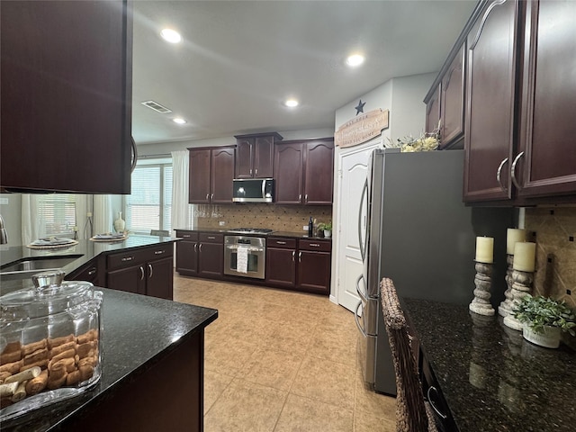 16506 Orchid Mist Dr, Cypress, TX 77433 - kitchen with appliances with stainless steel finishes, tasteful backsplash, dark brown cabinetry, dark stone counters, and recessed lighting