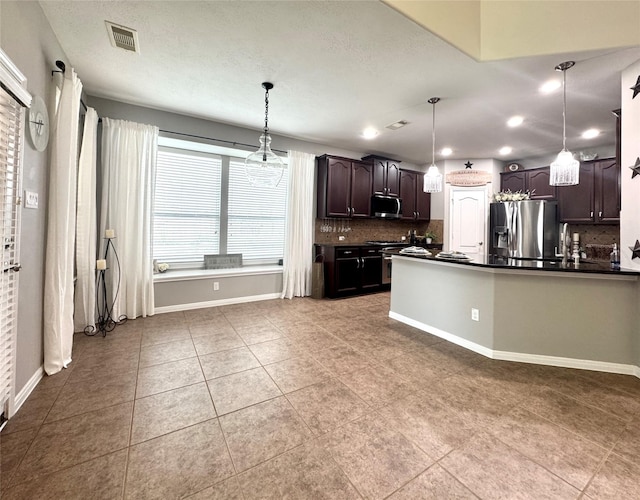 16506 Orchid Mist Dr, Cypress, TX 77433 - kitchen with appliances with stainless steel finishes, dark countertops, decorative backsplash, dark brown cabinets, and recessed lighting