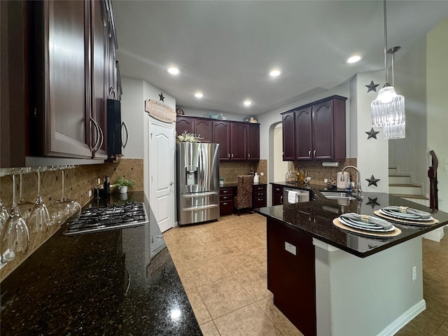 16506 Orchid Mist Dr, Cypress, TX 77433 - kitchen with appliances with stainless steel finishes, arched walkways, dark stone countertops, a peninsula, and backsplash