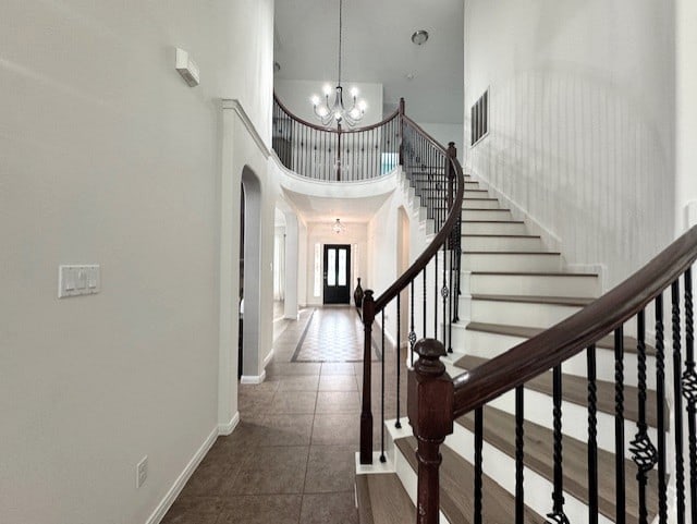 16506 Orchid Mist Dr, Cypress, TX 77433 - foyer entrance with a high ceiling, arched walkways, a chandelier, dark tile patterned flooring, and stairs