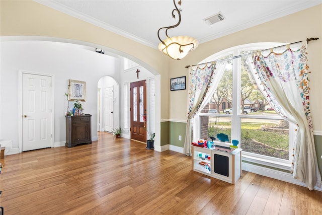 23602 Hawkins Creek Ct, Katy, TX 77494 - foyer with arched walkways, light wood finished floors, and ornamental molding
