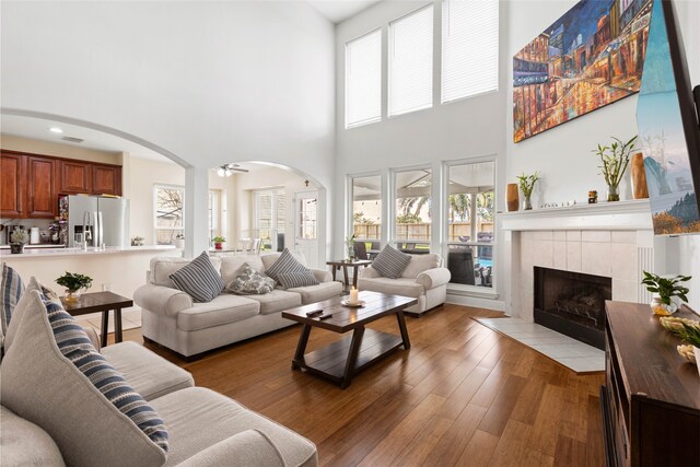 23602 Hawkins Creek Ct, Katy, TX 77494 - living area with a high ceiling, a fireplace, arched walkways, wood finished floors, and ceiling fan