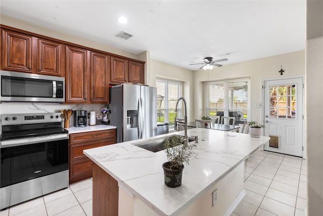 23602 Hawkins Creek Ct, Katy, TX 77494 - kitchen featuring appliances with stainless steel finishes, light tile patterned floors, ceiling fan, and light stone countertops