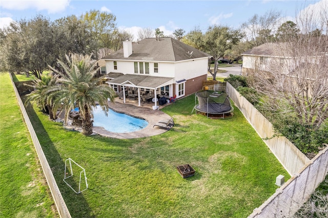 23602 Hawkins Creek Ct, Katy, TX 77494 - rear view of house with a fire pit, a trampoline, a fenced backyard, a chimney, and a patio