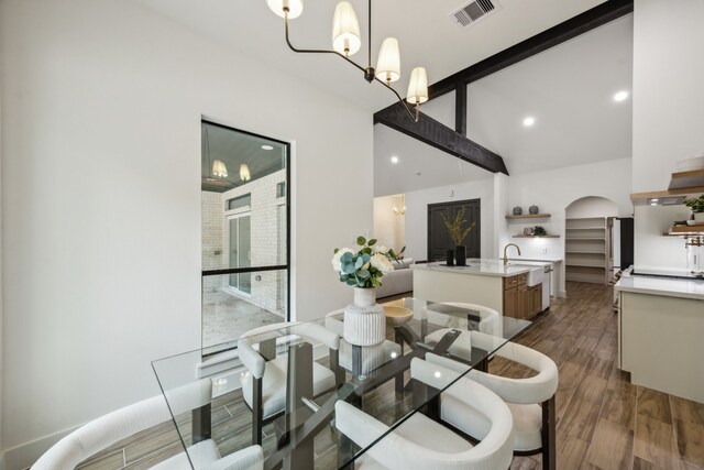 1265 Rd 66112, Dayton, TX 77535 - dining space featuring dark wood-style floors, high vaulted ceiling, beamed ceiling, arched walkways, and a chandelier