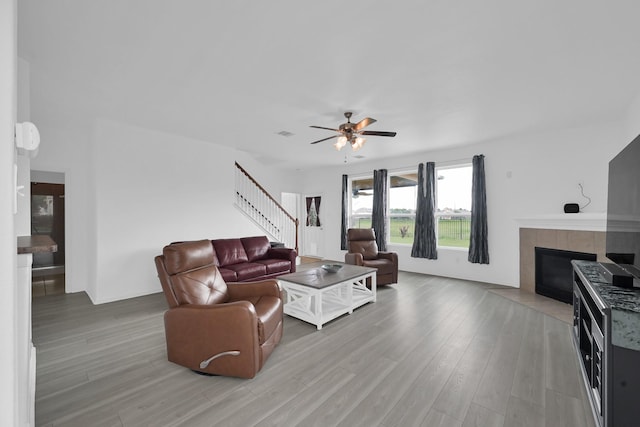 19210 Kent Park Dr, Tomball, TX 77375 - living area with ceiling fan, light wood finished floors, stairs, and a fireplace