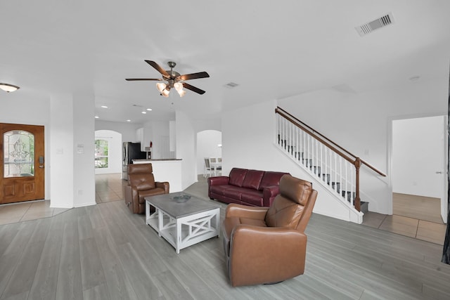 19210 Kent Park Dr, Tomball, TX 77375 - living area with arched walkways, light wood-style flooring, stairway, ceiling fan, and recessed lighting