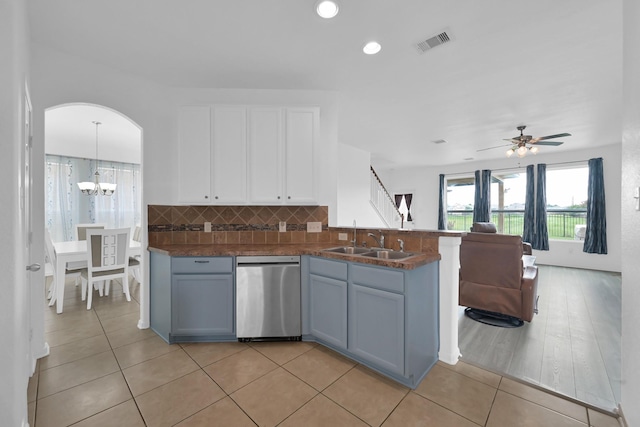 19210 Kent Park Dr, Tomball, TX 77375 - kitchen with stainless steel dishwasher, white cabinetry, dark countertops, backsplash, and a peninsula