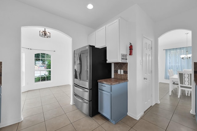 19210 Kent Park Dr, Tomball, TX 77375 - kitchen with arched walkways, smart refrigerator, light tile patterned floors, and a chandelier