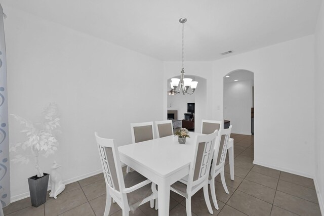 19210 Kent Park Dr, Tomball, TX 77375 - dining space featuring arched walkways, a chandelier, and tile patterned floors