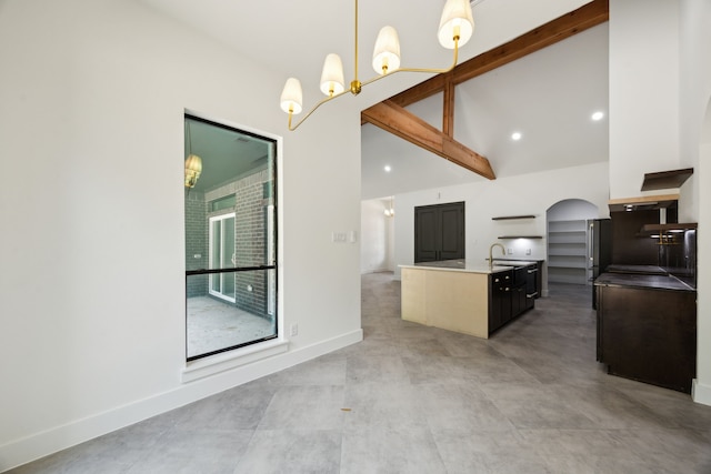 1253 Rd 66112, Dayton, TX 77535 - kitchen featuring high vaulted ceiling, a chandelier, a kitchen island with sink, arched walkways, and hanging light fixtures