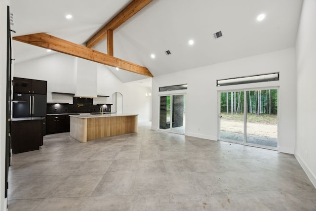 1253 Rd 66112, Dayton, TX 77535 - kitchen with high vaulted ceiling, open floor plan, a kitchen island with sink, beamed ceiling, and tasteful backsplash