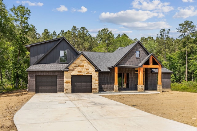 1253 Rd 66112, Dayton, TX 77535 - view of front facade featuring board and batten siding, concrete driveway, stone siding, brick siding, and a garage