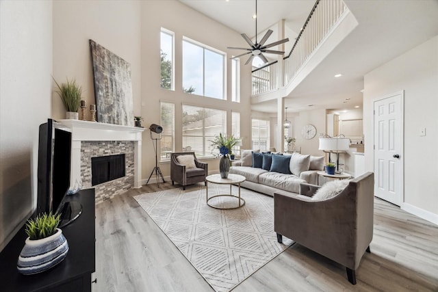 13411 Via Chianti Ln, Cypress, TX 77429 - living area featuring a fireplace, a high ceiling, light wood finished floors, and a ceiling fan