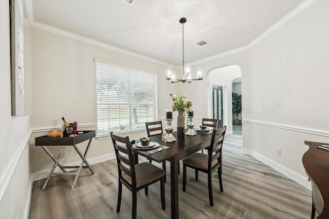 13411 Via Chianti Ln, Cypress, TX 77429 - dining space with arched walkways, light wood-style flooring, ornamental molding, and a chandelier