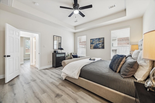 13411 Via Chianti Ln, Cypress, TX 77429 - bedroom with a raised ceiling, light wood-style floors, and ceiling fan