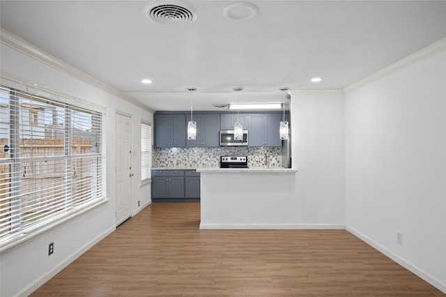 3835 Tartan Ln, Houston, TX 77025 - kitchen with stainless steel appliances, gray cabinets, ornamental molding, wood finished floors, and backsplash