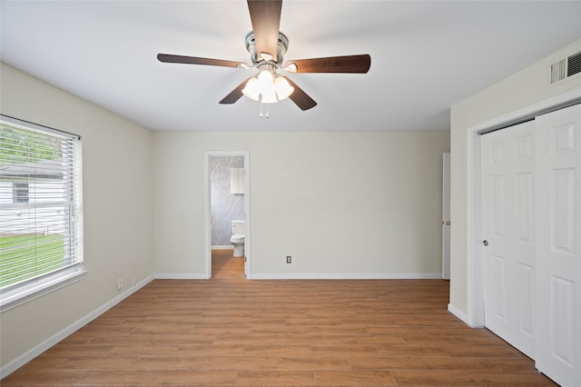 3835 Tartan Ln, Houston, TX 77025 - unfurnished bedroom with a closet, light wood finished floors, ceiling fan, and connected bathroom