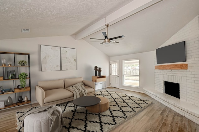 2330 Grindstone Ln, Sugar Land, TX 77498 - living area with a ceiling fan, wood finished floors, a textured ceiling, and a brick fireplace