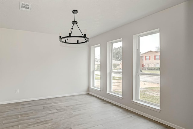 2330 Grindstone Ln, Sugar Land, TX 77498 - unfurnished dining area featuring a chandelier, plenty of natural light, and light wood-type flooring