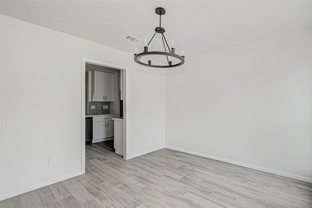 2330 Grindstone Ln, Sugar Land, TX 77498 - empty room with a chandelier and light wood-style floors