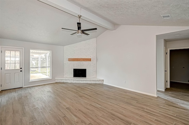 2330 Grindstone Ln, Sugar Land, TX 77498 - unfurnished living room with a textured ceiling, a ceiling fan, light wood-type flooring, and a brick fireplace