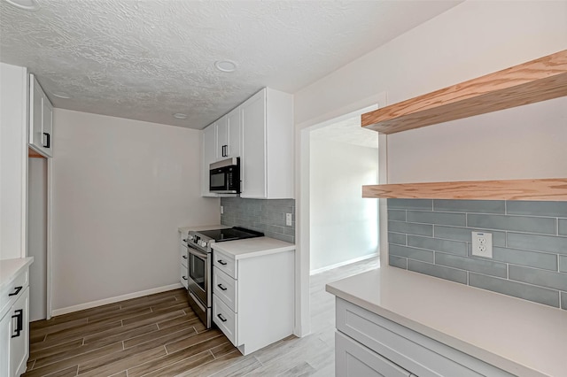 2330 Grindstone Ln, Sugar Land, TX 77498 - kitchen featuring stainless steel electric range oven, wood finished floors, decorative backsplash, light countertops, and white cabinetry