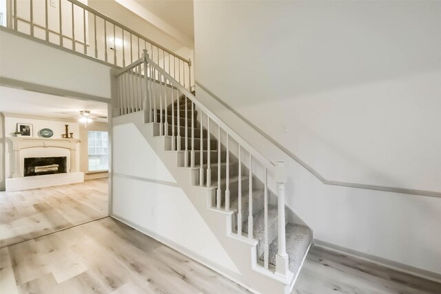 4214 Brightwood Dr, Houston, TX 77068 - stairs featuring wood finished floors, a fireplace with raised hearth, and ceiling fan