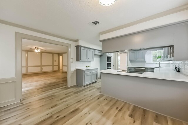 4214 Brightwood Dr, Houston, TX 77068 - kitchen with light wood-style flooring, a peninsula, gray cabinets, light countertops, and black electric stovetop