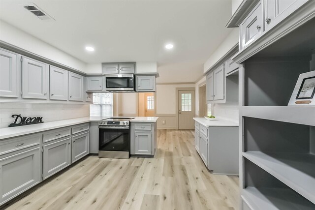 4214 Brightwood Dr, Houston, TX 77068 - kitchen featuring gray cabinetry, appliances with stainless steel finishes, a peninsula, light wood-style floors, and light countertops