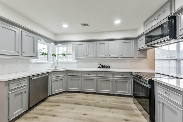 4214 Brightwood Dr, Houston, TX 77068 - kitchen featuring stainless steel appliances, gray cabinetry, light wood-style flooring, and recessed lighting