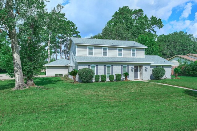 725 River Plantation Dr, Conroe, TX 77302 - view of front of home featuring a front lawn, a shingled roof, and brick siding