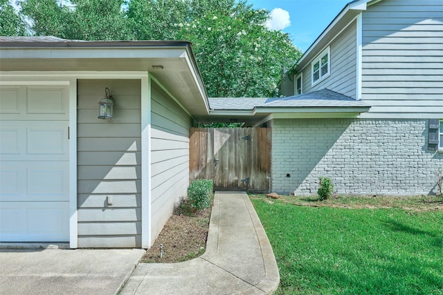 725 River Plantation Dr, Conroe, TX 77302 - view of exterior entry with brick siding, a lawn, an attached garage, and roof with shingles