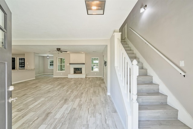 725 River Plantation Dr, Conroe, TX 77302 - staircase featuring wood finished floors, a brick fireplace, and a ceiling fan