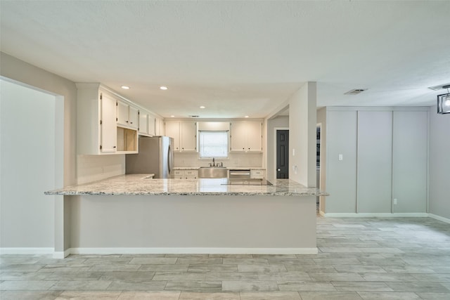 725 River Plantation Dr, Conroe, TX 77302 - kitchen featuring stainless steel appliances, a peninsula, light stone countertops, wood tiled floors, and backsplash