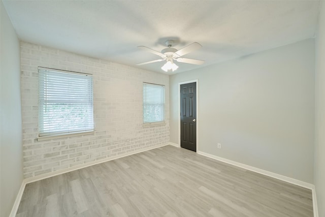 725 River Plantation Dr, Conroe, TX 77302 - empty room featuring wood finished floors, ceiling fan, and brick wall