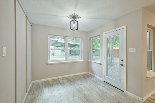 725 River Plantation Dr, Conroe, TX 77302 - unfurnished dining area featuring light wood-type flooring and a textured ceiling