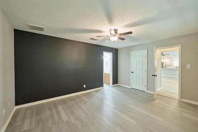 725 River Plantation Dr, Conroe, TX 77302 - empty room featuring ceiling fan, light wood-style floors, and a textured ceiling